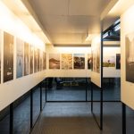 Galeria de arte iluminada com fotografias expostas em painéis nas paredes