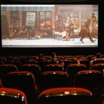 Público assiste a um filme de animação em uma sala de cinema.