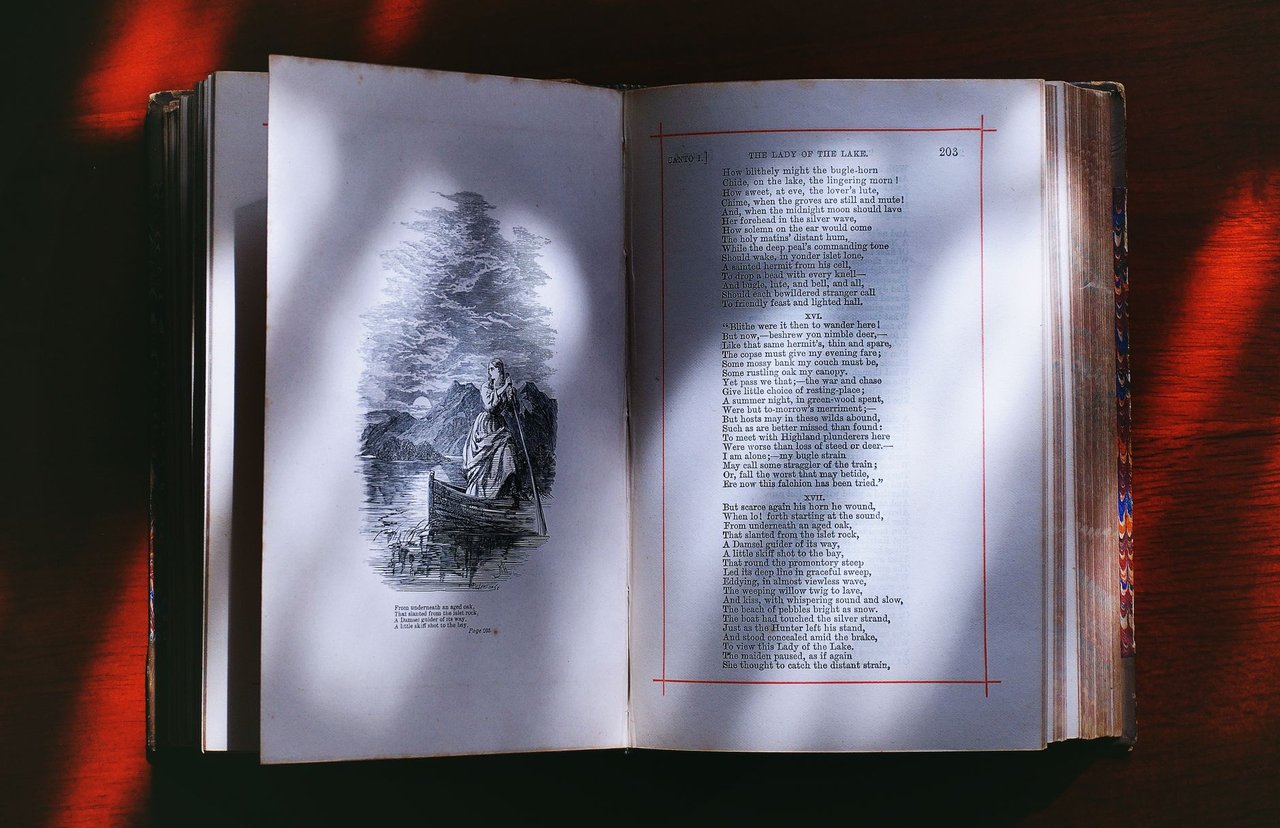 Livro antigo aberto exibe páginas com ilustrações e versos, em composição que remete à literatura popular.