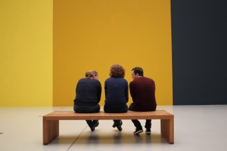 Visitantes observam obras expostas em uma galeria de arte.